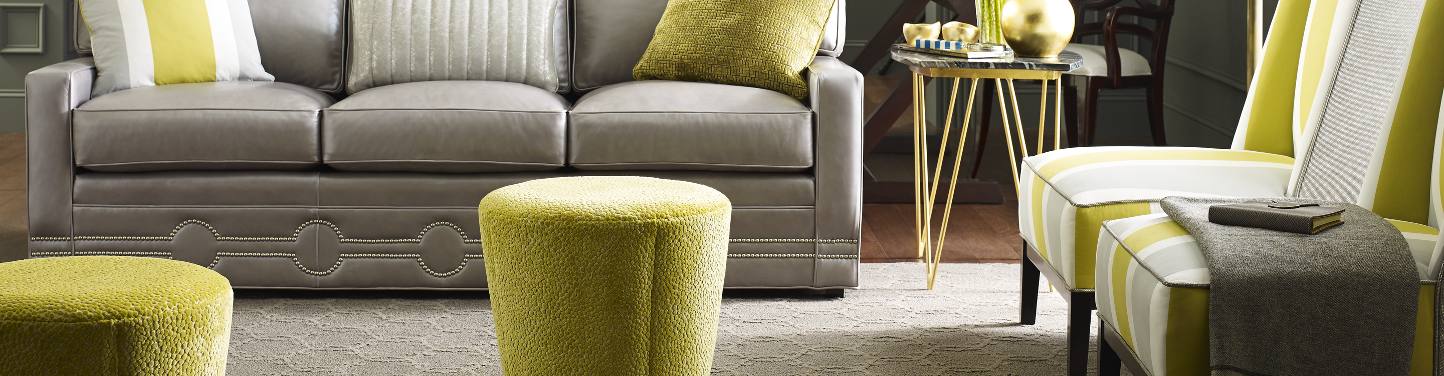 custom neutral patterned area rug in living room with grey sofa and green accent pillow